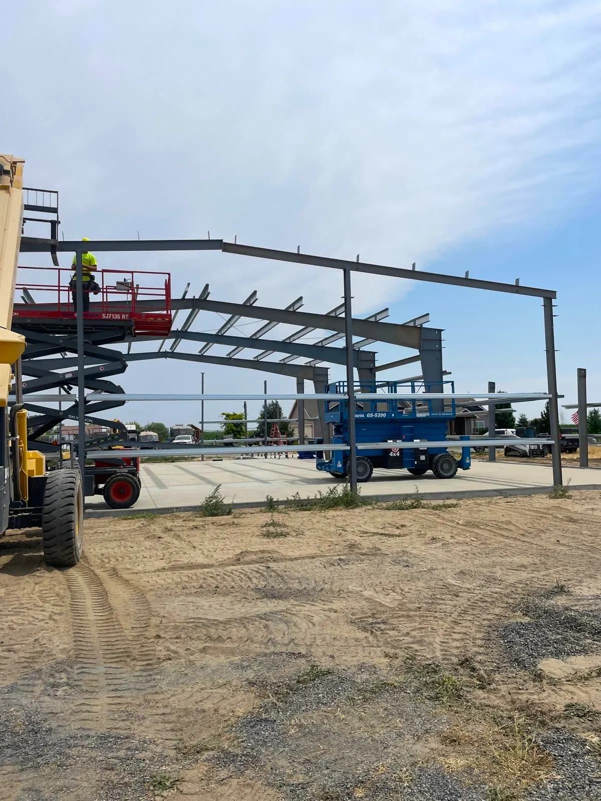 Boom lift crew erecting steel framing on a building under construction