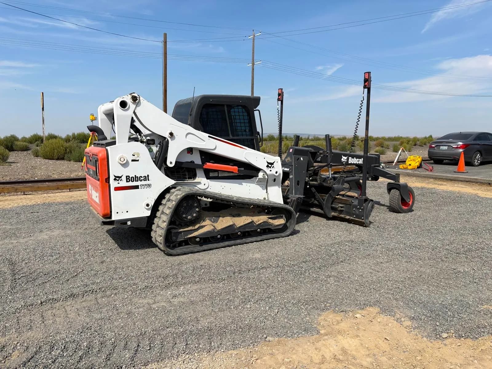 Skid steer trencher attachment cutting a utility trench