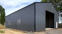 Exterior of a completed gray metal building with windows and a large open bay
